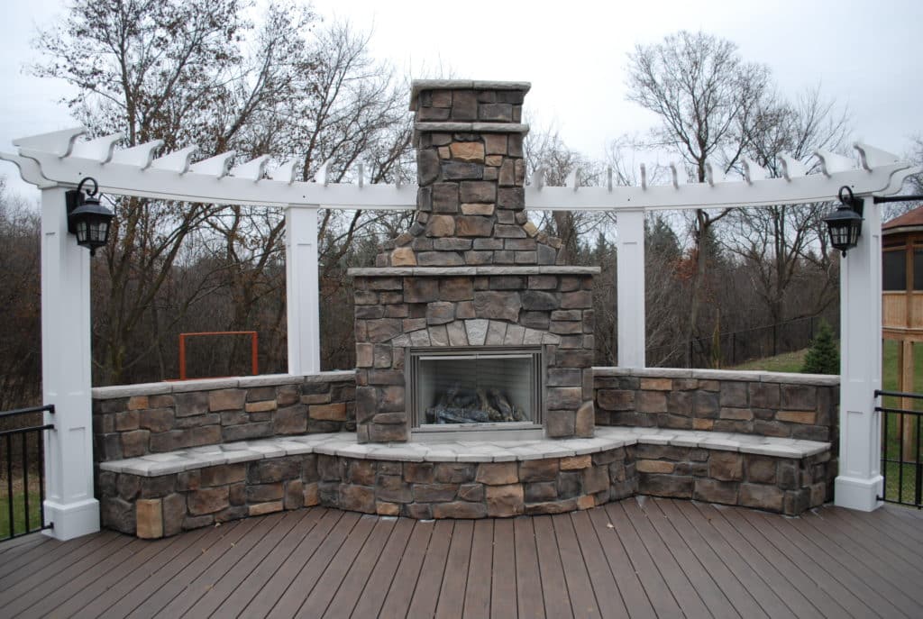 Stunning fireplace on a deck with a pergola accent