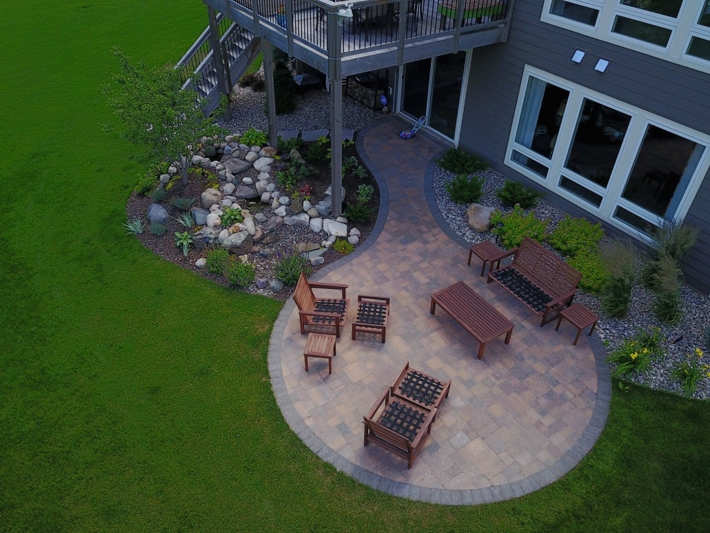 A picturesque circle patio and water fall in a serene backyard. 